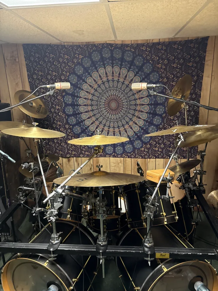 Drum kit with overhead microphones in recording studio